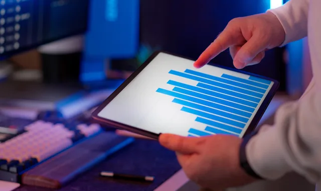 Business professional analyzing bar chart on tablet in office setting, highlighting data insights. Key metrics for professional services marketing explained